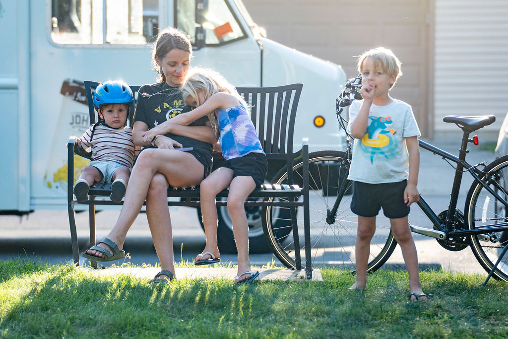 Kids sitting on bench at a park in the Village of Marble Cliff